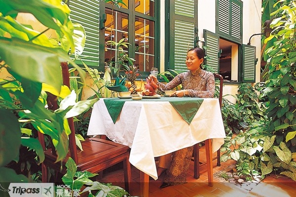 遊客可以選擇坐在植滿花草的庭院享用越南美食。（圖片提供／墨刻編輯部）