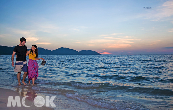 和情人牽著手海邊漫步，夕陽在輕柔和緩的浪濤聲中，將天際染成一片晚霞。（圖片提供／馬來西亞觀光局）