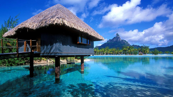 清澈的海水與絕美的景色，加上一棟水上小木屋，讓兩人相依偎在甜蜜的浪漫時光。（圖片來源／取自luxatic.com）