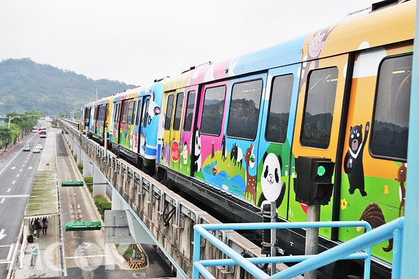 車廂外觀彩繪著圓仔、台灣黑熊和其他的動物，就連下方公車候車亭的民眾也忍不住仰望著可愛的彩繪列車。（攝影／暴坊薑軍）