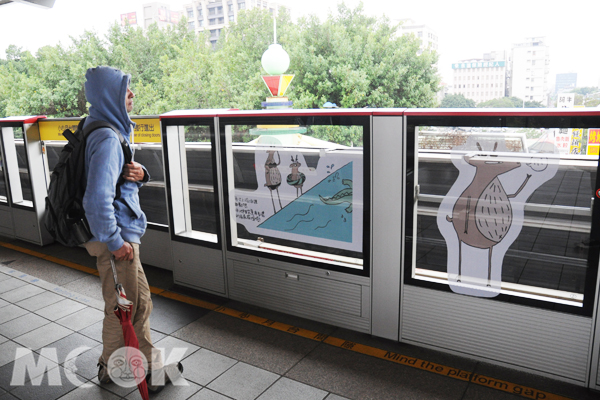 等車的過程中，乘客仔細欣賞麋鹿先生的插畫。(攝影／MOOK景點家廖啟佑）