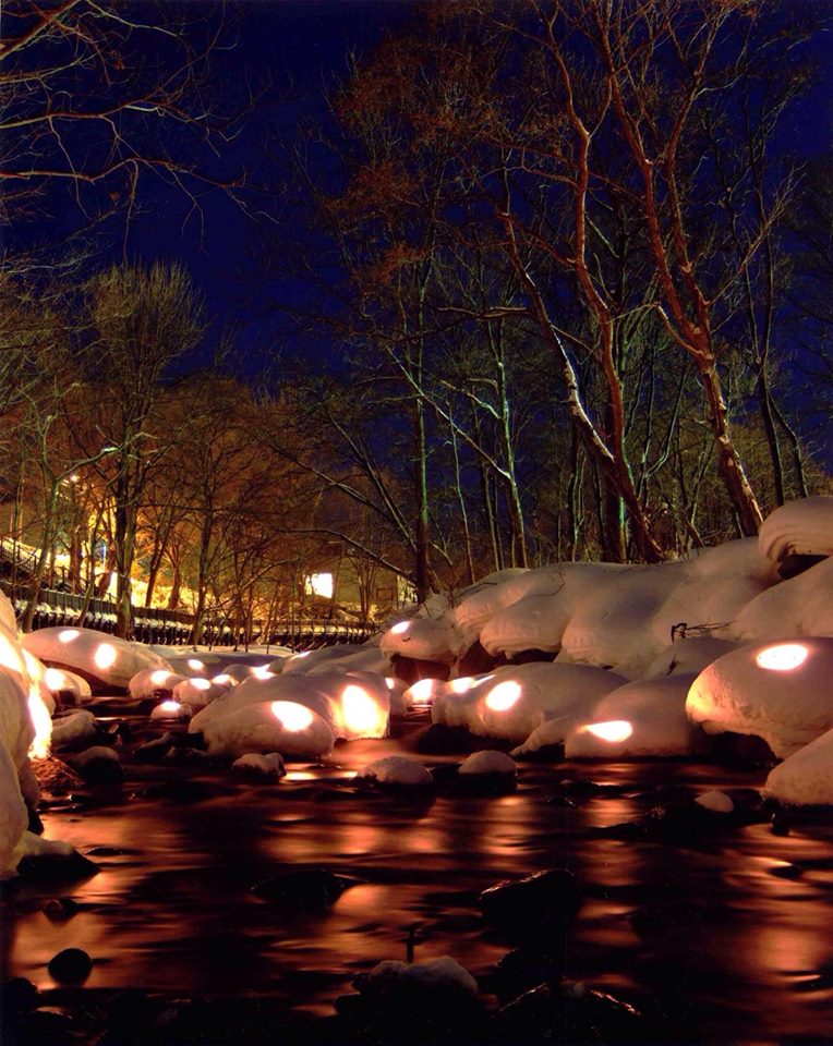 夜裡雪景河畔，透過溫暖燈光，充滿了浪漫氣息。(圖片來源／小樽雪あかりの路）