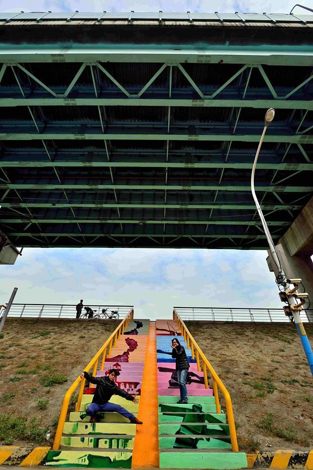 普普風大作(女王頭、三貂角燈塔、淡水情人橋、朱銘博物館)，此座樓梯位於五股五權一路與五工一路交接口。(圖片來源／新北市水利局）