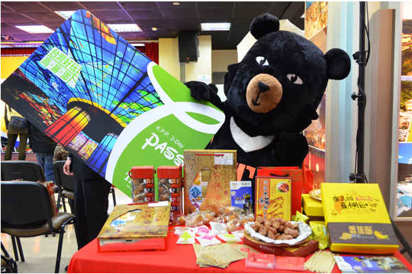 台灣喔熊拿著台灣好玩卡開心推介高雄特色伴手禮。（圖片來源／台灣觀光局）