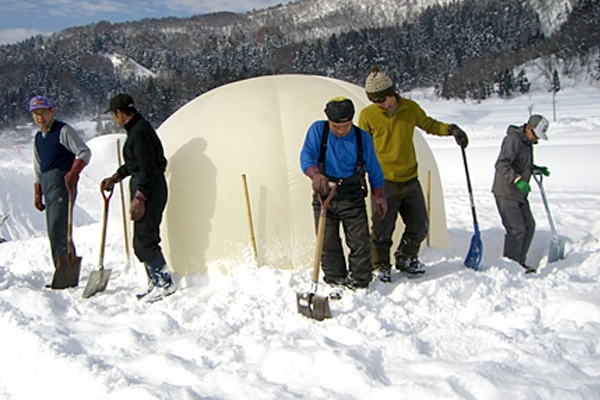 村民先在大汽球上堆上雪，待穩固後再將氣球放掉留下雪屋空間。(圖片來源／iiyama-ouendan)