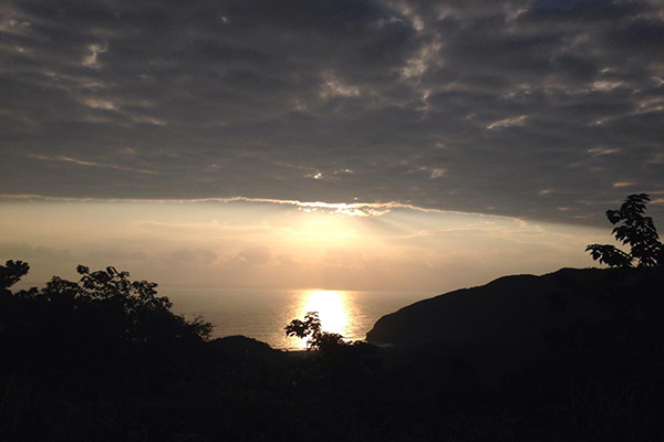 日出的光芒穿透雲層照撒在牛山呼庭與太平洋 (圖片來源／牛山呼庭)