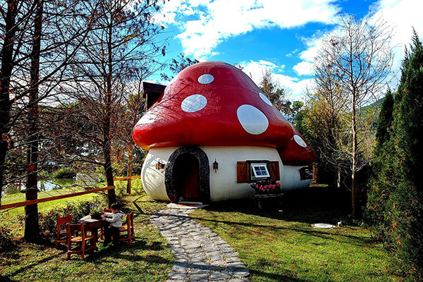 紅色蘑菇屋，在藍天白雲下看起來特別亮眼可愛 (圖／花見幸福莊園-花蓮民宿)