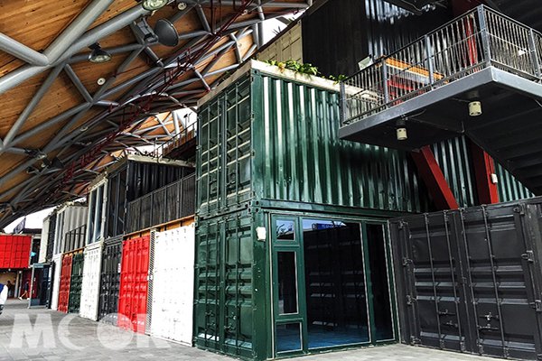 內部採用不同顏色的貨櫃聚集推疊，貨櫃屋頂也使用了綠色植物點綴 (圖片提供／orbischen)