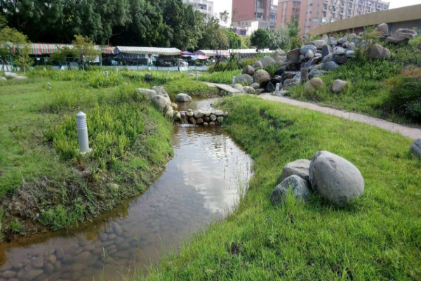 公園設計改為視野開闊的草坡，並以麗池為源頭打造瀑布流水。