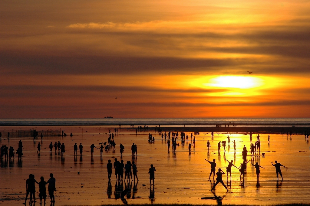 高美濕地的夕陽，眾人踩踏在淺灘上剪影如畫，但要注意跨年當日的氣溫。 (圖／台灣觀光局）