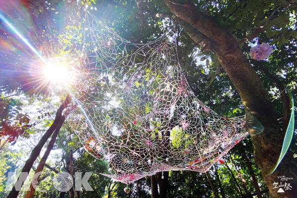 《團結織網》利用廢棄塑膠回收資源編織巨大蜘網，隱含著在地居民團結的社群意識