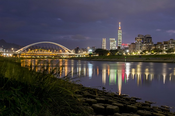 以101及台北城市閃爍的燈光為背景，搭配倒映河面的橋景，令人炫目。