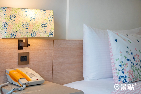 床頭燈罩呼應印花主題，暖橘色系的燈光讓旅人能得到完全的放鬆。