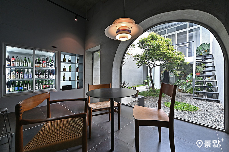 吧台後方空間是屋物清酒店內最受歡迎的位置，水泥拱型窗環抱中庭綠意，坐在丹麥設計師經典椅上，品飲清酒與春光，極為愜意。