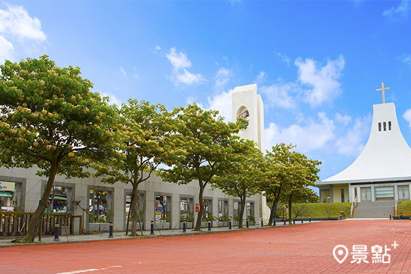 校門口步道加羅林魚木搭配白鐘樓，景致漂亮又浪漫。(圖／聖約翰科技大學)