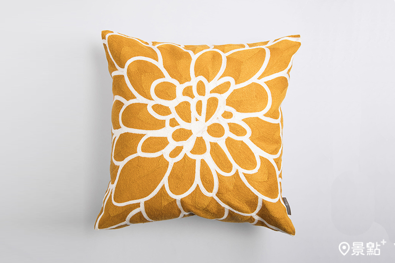 山茶花滿版繡抱枕，採用讓人聯想到陽光的黃色，放置在客廳空間中有帶動氛圍的效果。