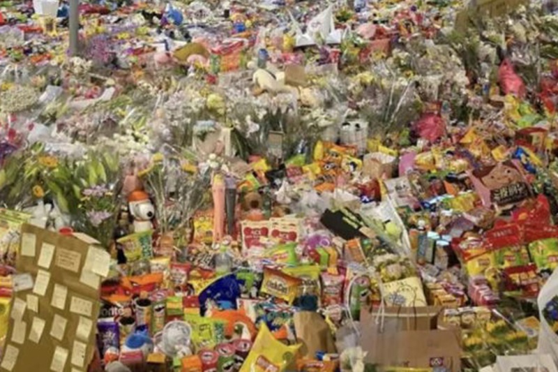 民眾自發性追思悼念物品擺滿了事發路口附近的草地上。