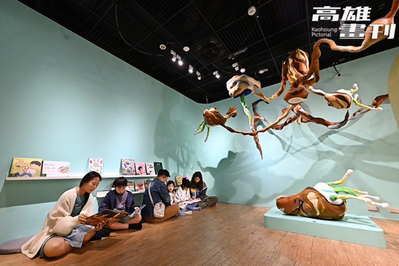巨大花生下，親子席地共讀繪本，讓看展覽過程中也能有溫馨的親子時光。(攝影/Carter)